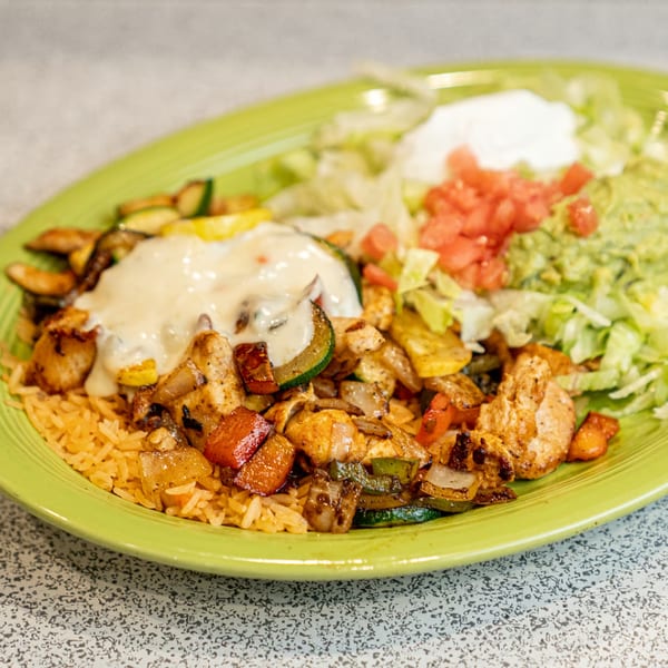 El Paso Mexican Restaurant's chicken fajita with rice, vegetables, and a side of guacamole and sour cream.
