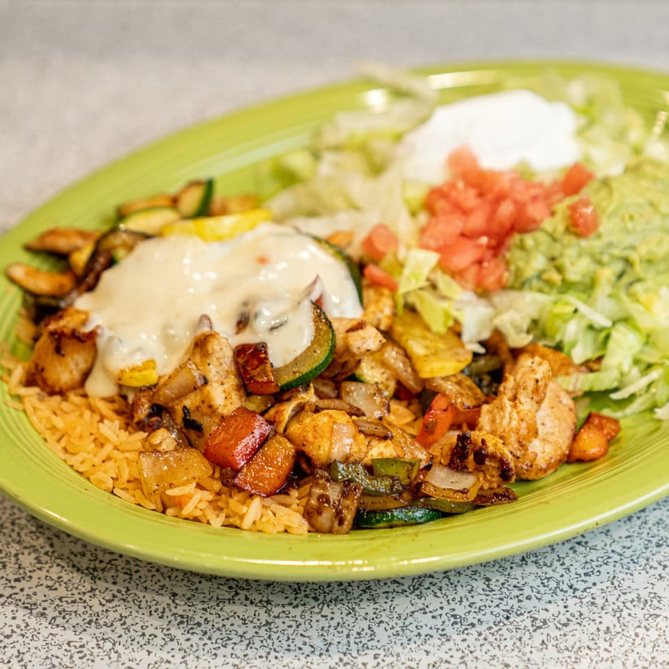 El Paso Mexican Restaurant's chicken fajita with rice, vegetables, and a side of guacamole and sour cream.
