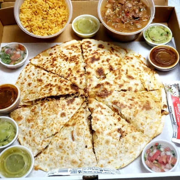 El Paso Mexican Restaurant's quesadilla with rice, beans, and various dipping sauces in a takeout box.