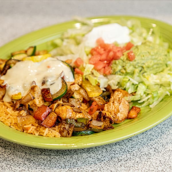 El Paso Mexican Restaurant's chicken fajita with rice, vegetables, cheese sauce, guacamole, and salsa.
